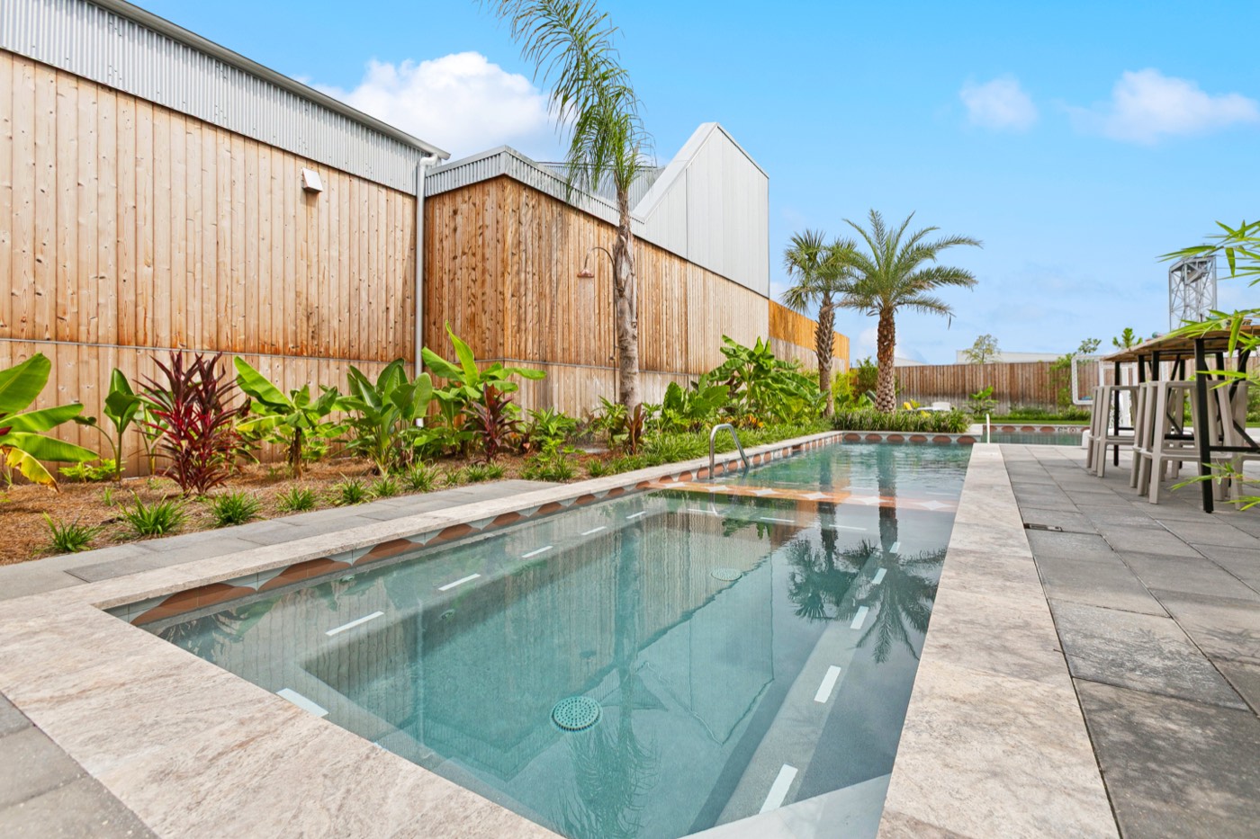Long heated pool with tropical landscaping at Castleday Retreats